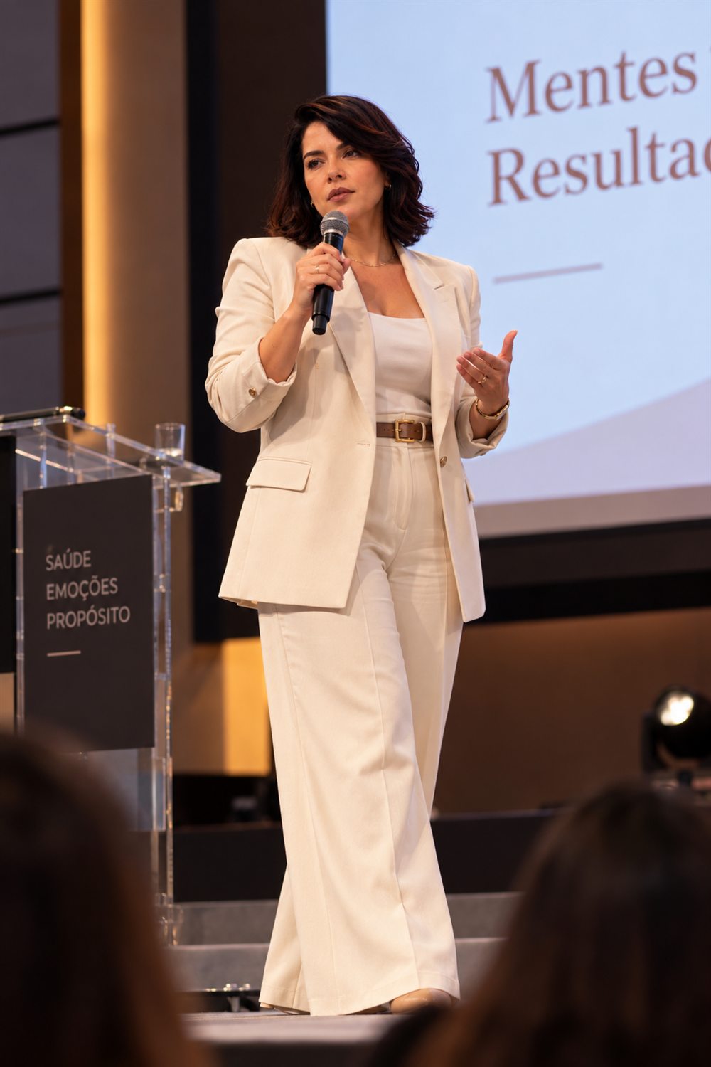 Karla Krigare palestrando no palco, com microfone na mão